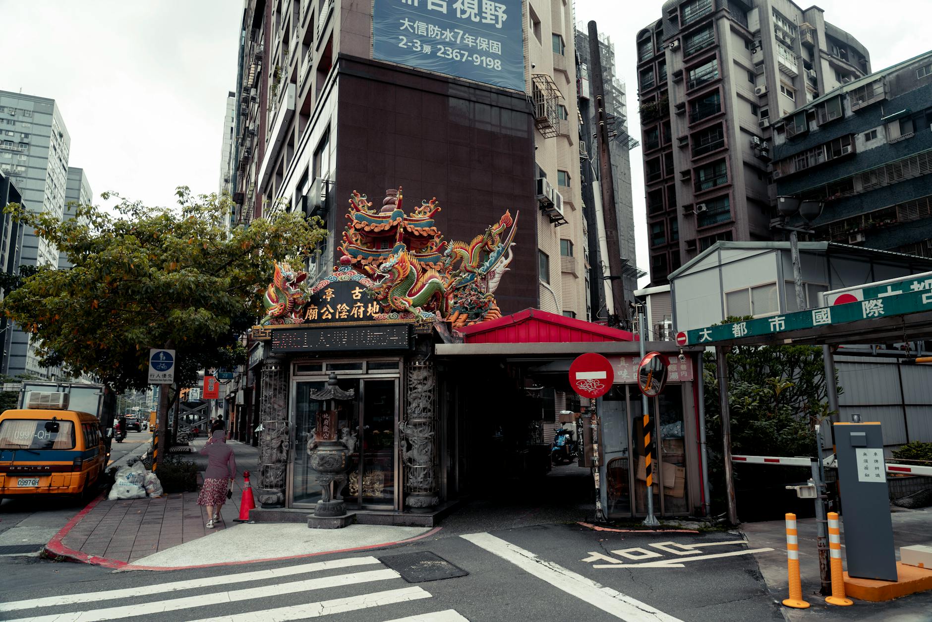 Colorful traditional entrance on a bustling street corner in Taipei, Taiwan's vibrant urban landscape.