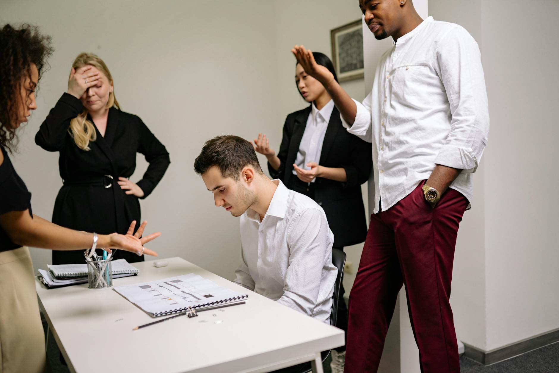 Business professionals engaged in a tense discussion at the office, highlighting workplace conflict.