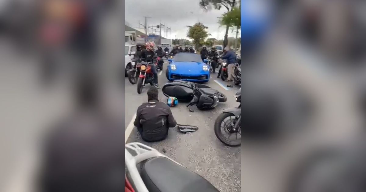 Avenida dos Bandeirantes em São Paulo, com tráfego intenso de carros e motos, próximo a uma área urbana densa.