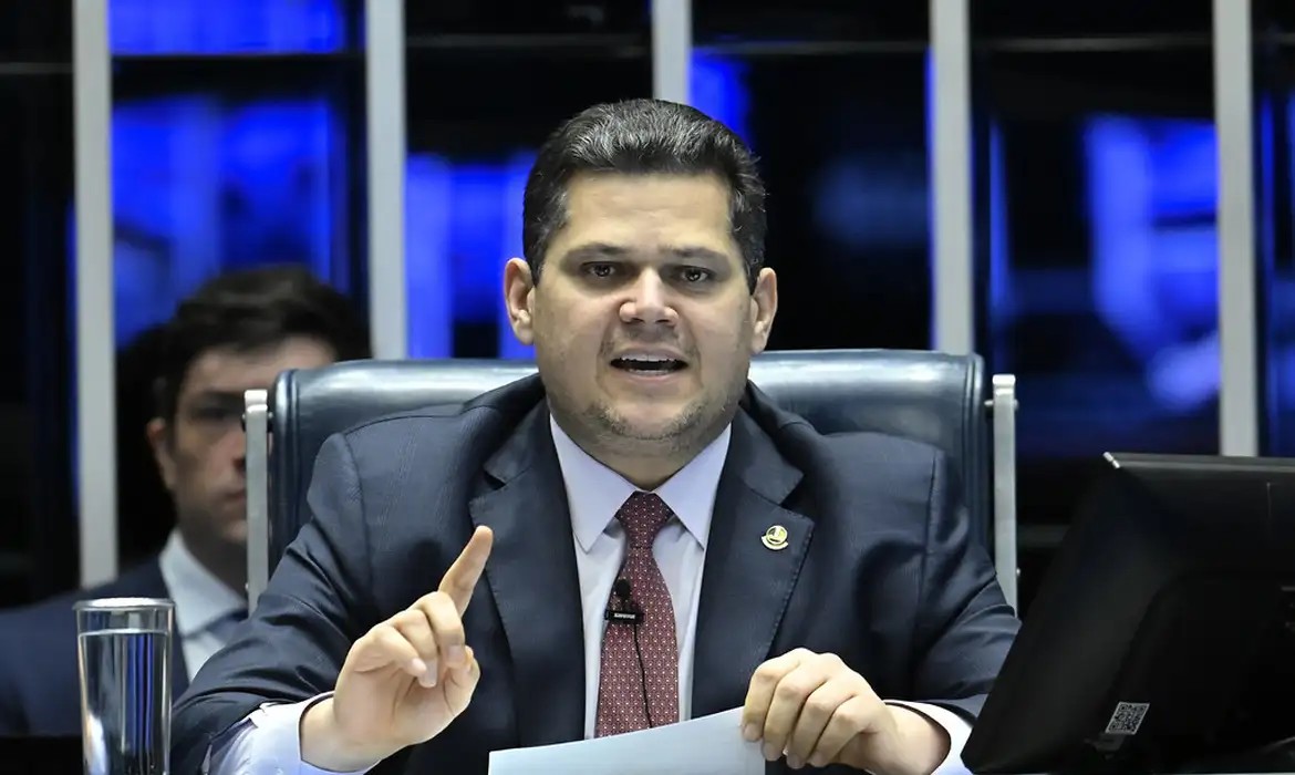 Senador Davi Alcolumbre em pronunciamento no plenário do Senado Federal, com microfones à frente.