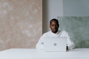 A business professional works intently on a laptop in a modern office setting.