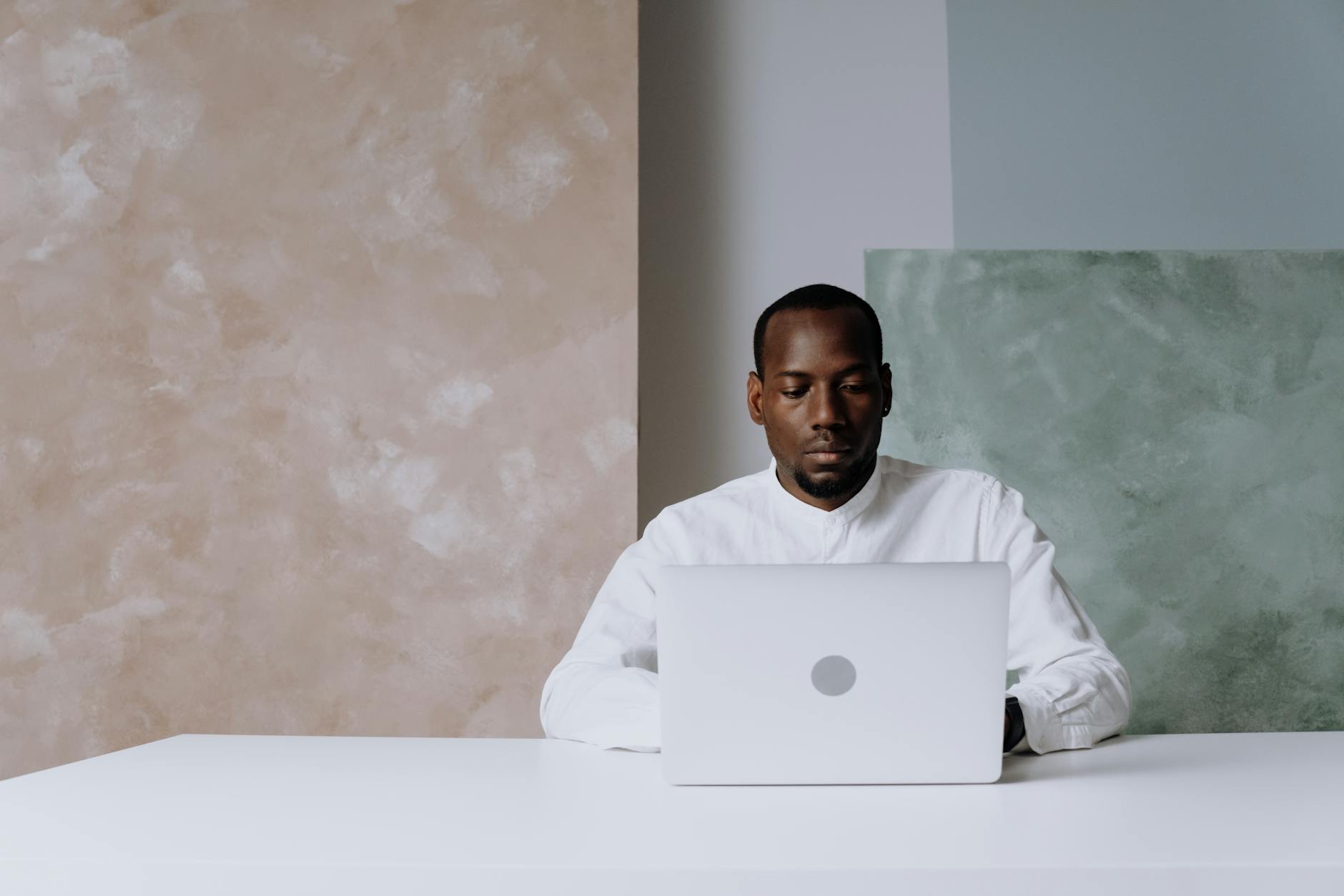 A business professional works intently on a laptop in a modern office setting.