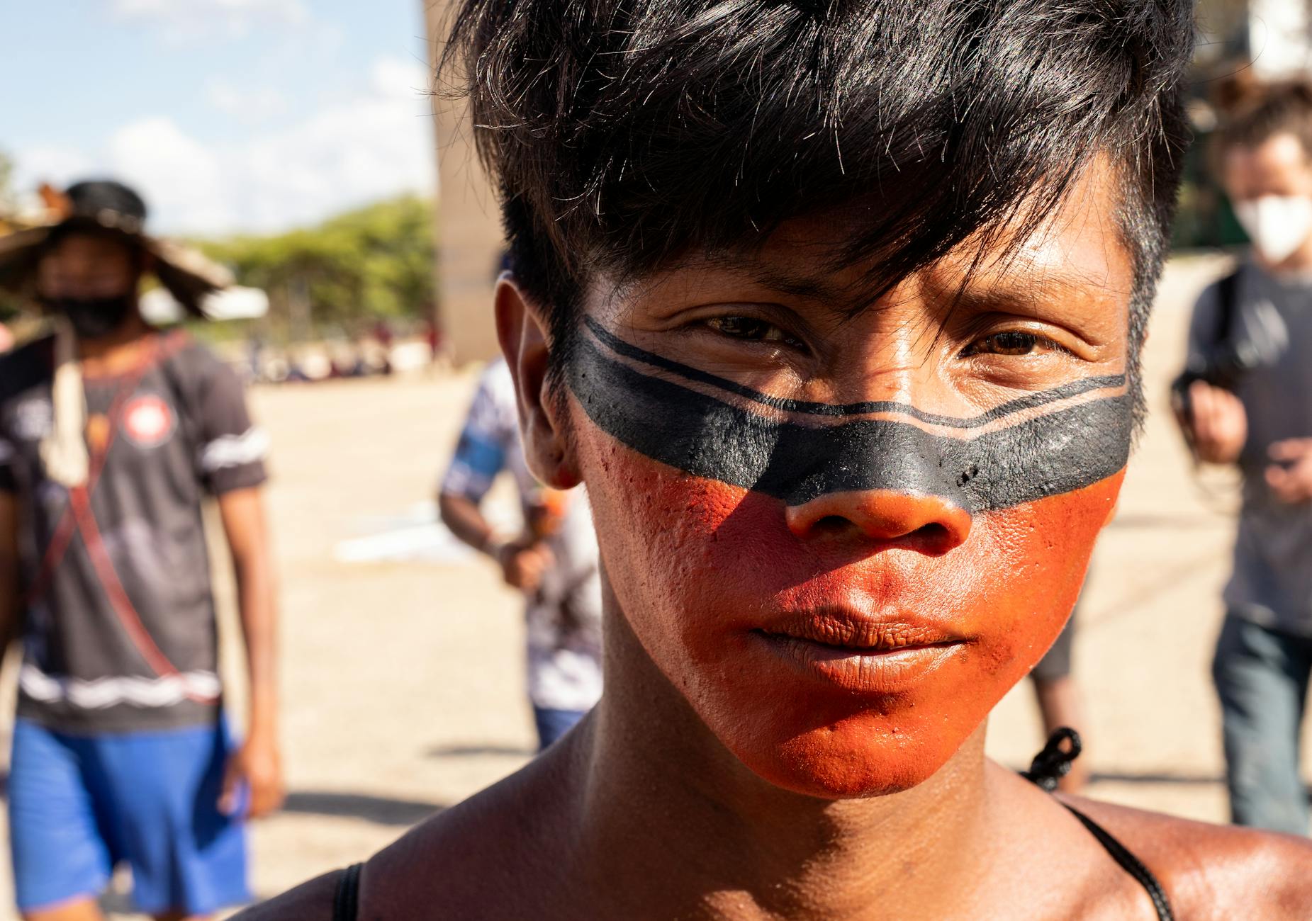 Close-up of an indigenous individual with face paint, representing cultural expression in Brazil.